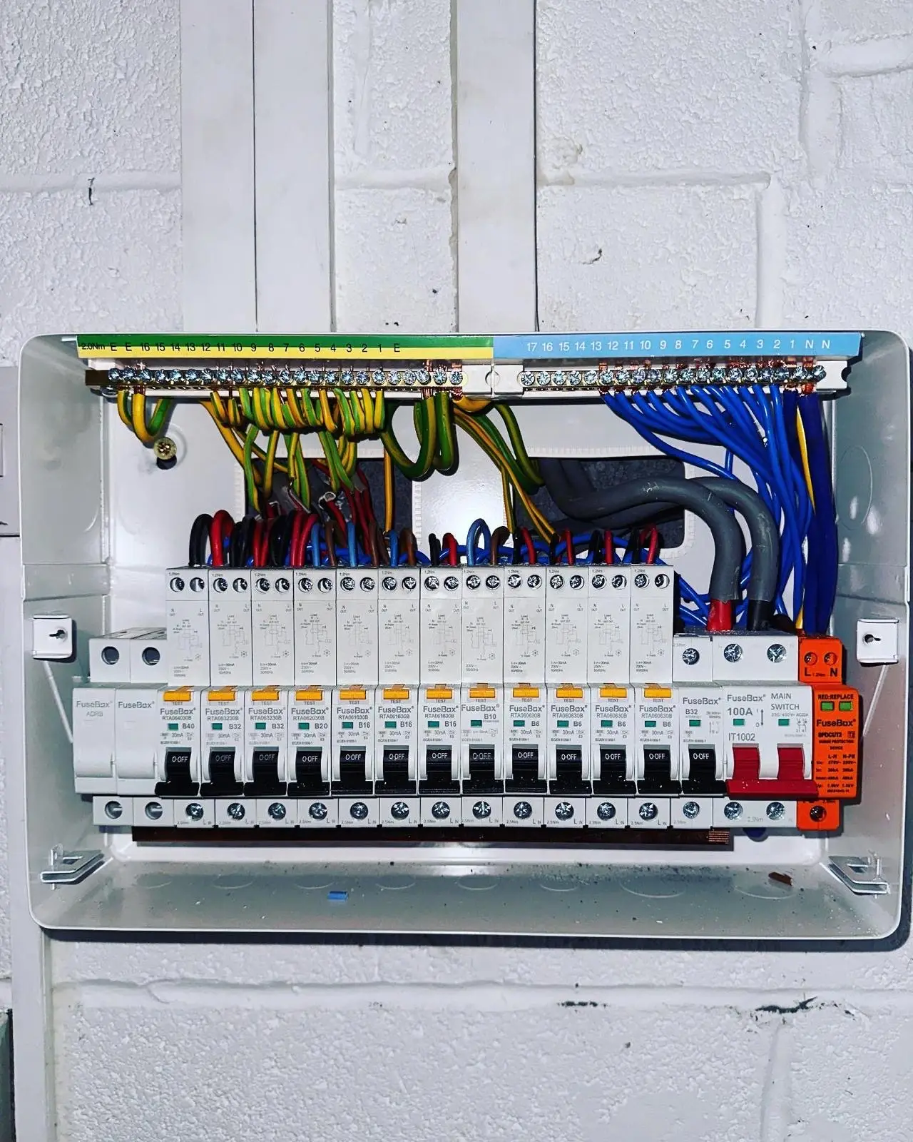 A new consumer unit with the cover off, showing a row of RCBOs, the main switch, a surge protection device and neatly dressed wiring.