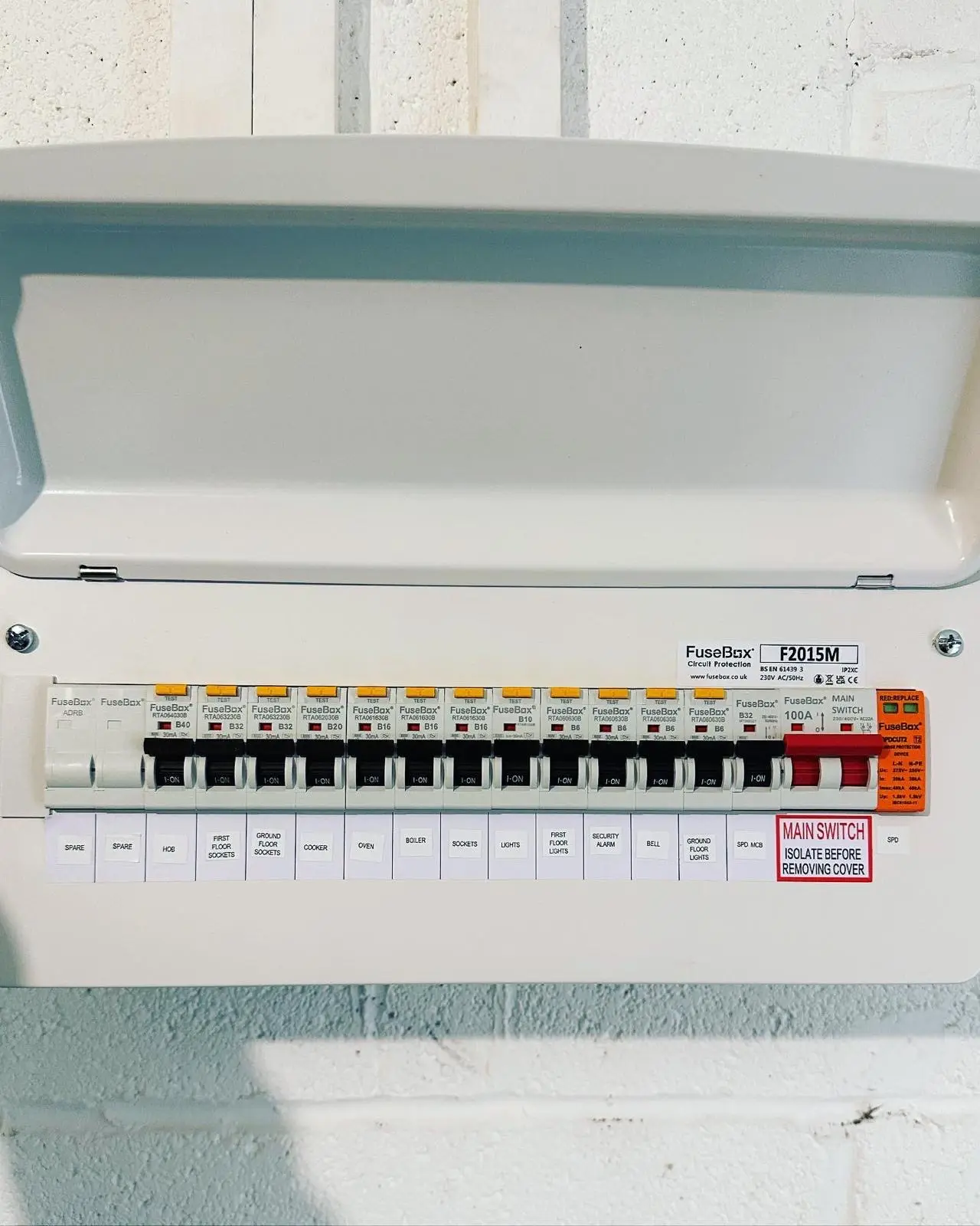 A new RCBO consumer unit with its lid open and every circuit labelled beneath the breakers, including the hob, cooker, sockets, lights, boiler and alarm.