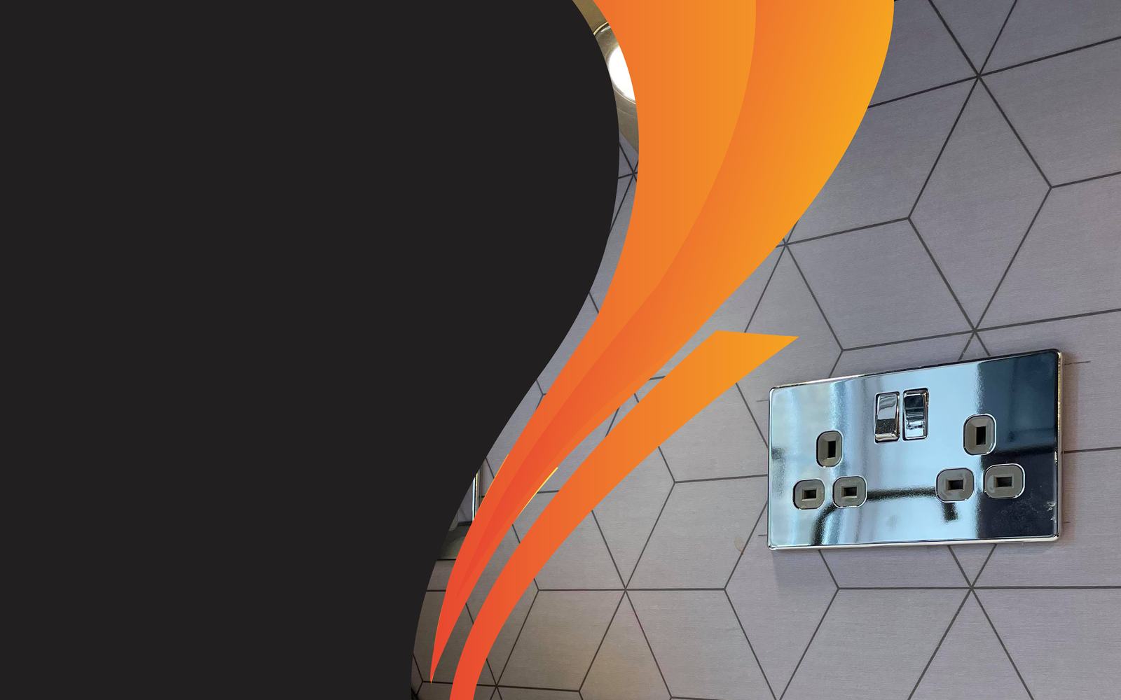 A chrome double socket on a hexagonal-tiled wall, with the Gilfoyle Electrical orange swoosh